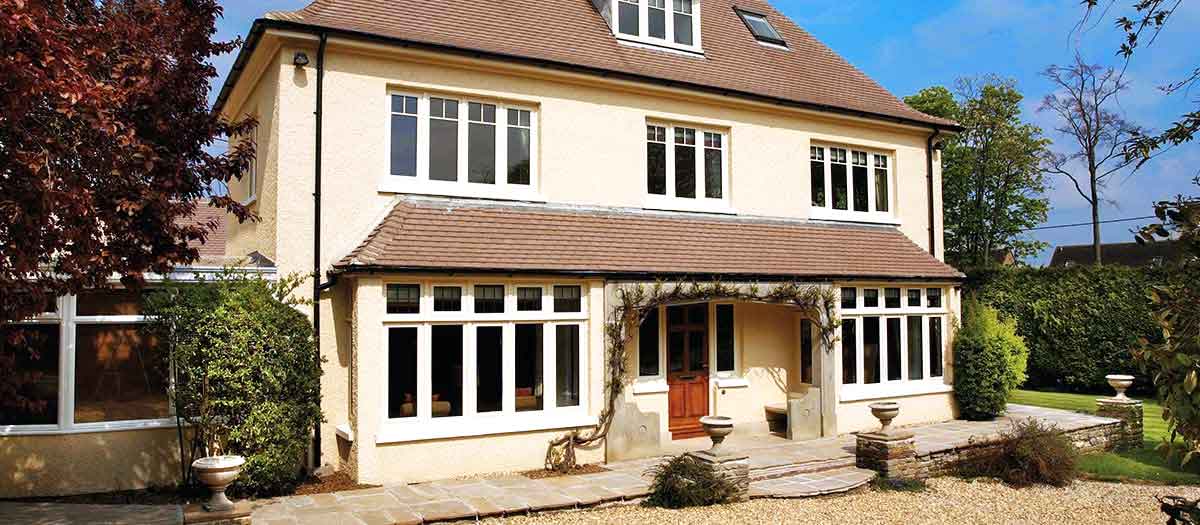 Cream house with white windows and brown entrance door