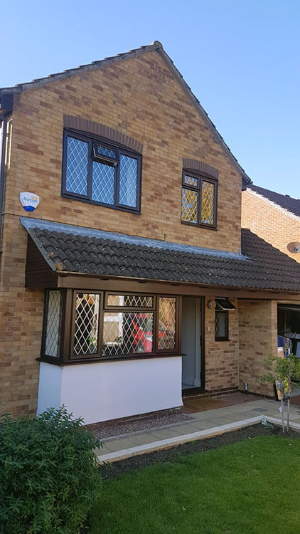 Family home with rosewood upvc casement windows and chrome bars