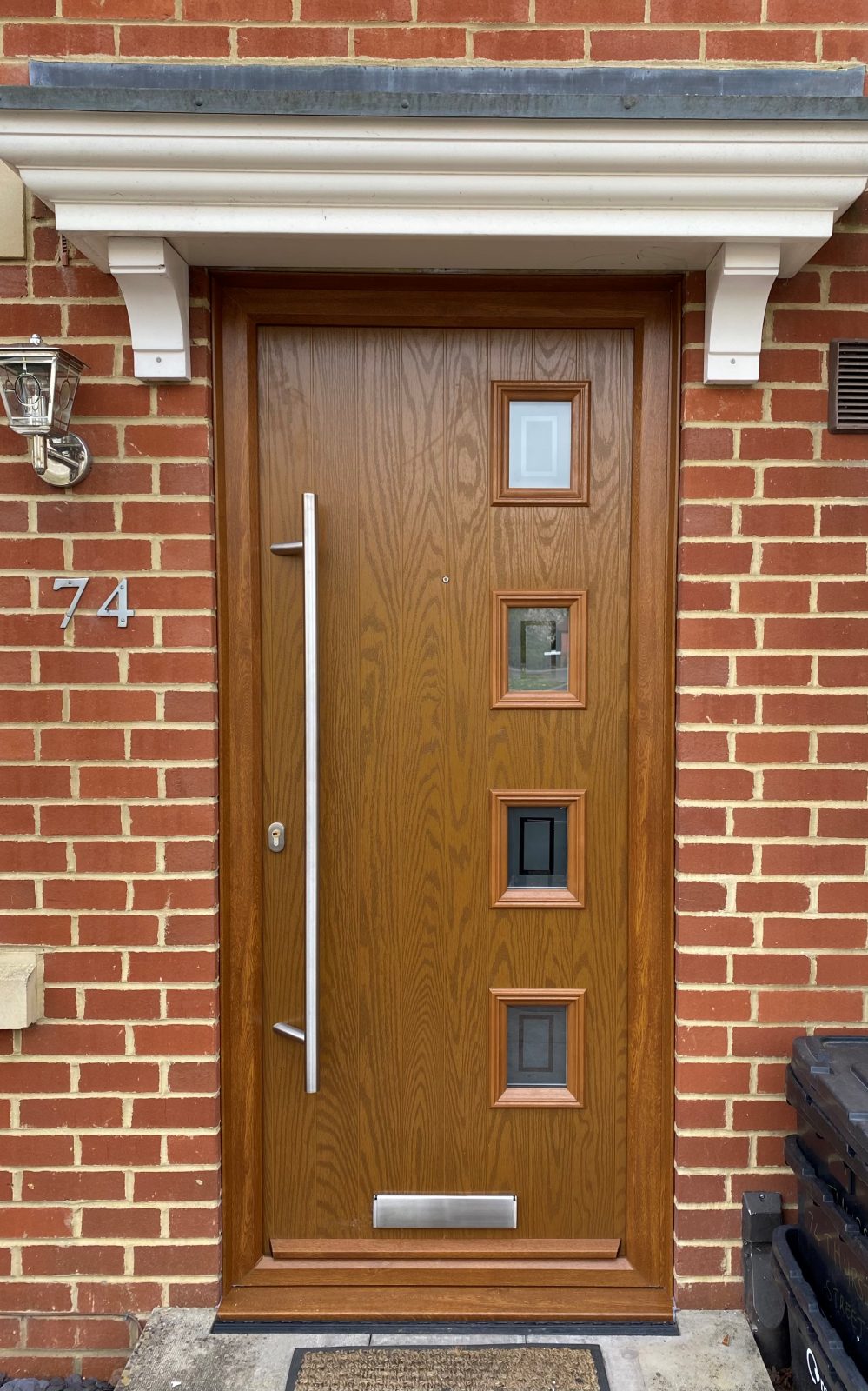 Timber effect door with small square windows.