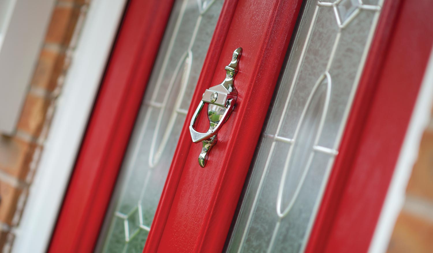 Red composite entrance door with glazed panels and chrome hardware