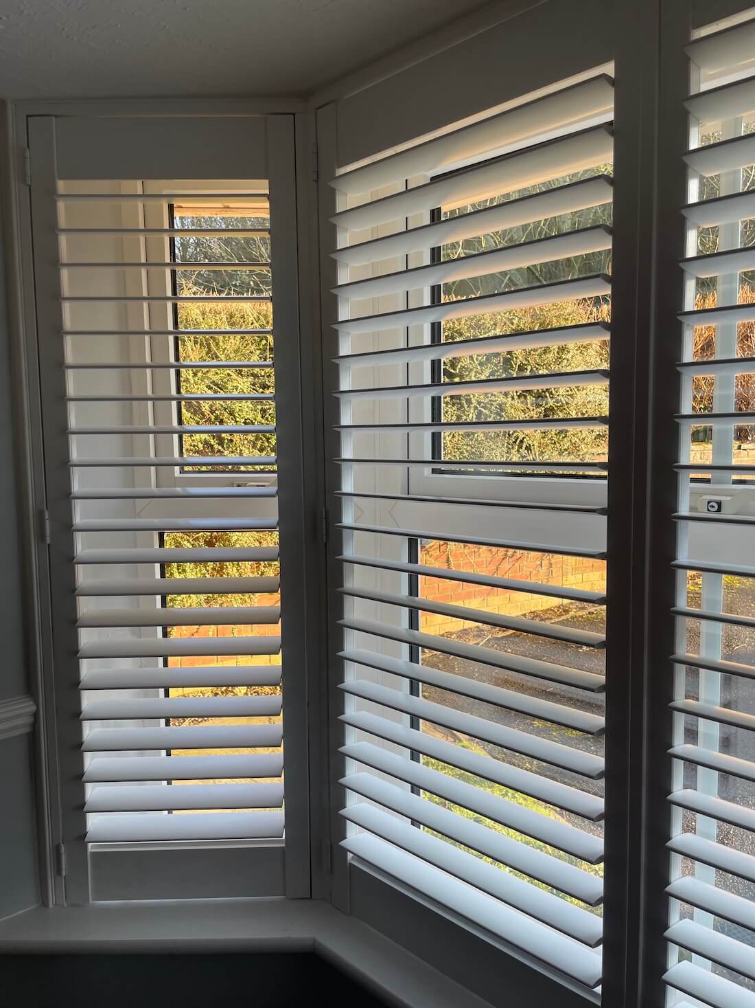 White shutters in a back bedroom overlooking the front garden.