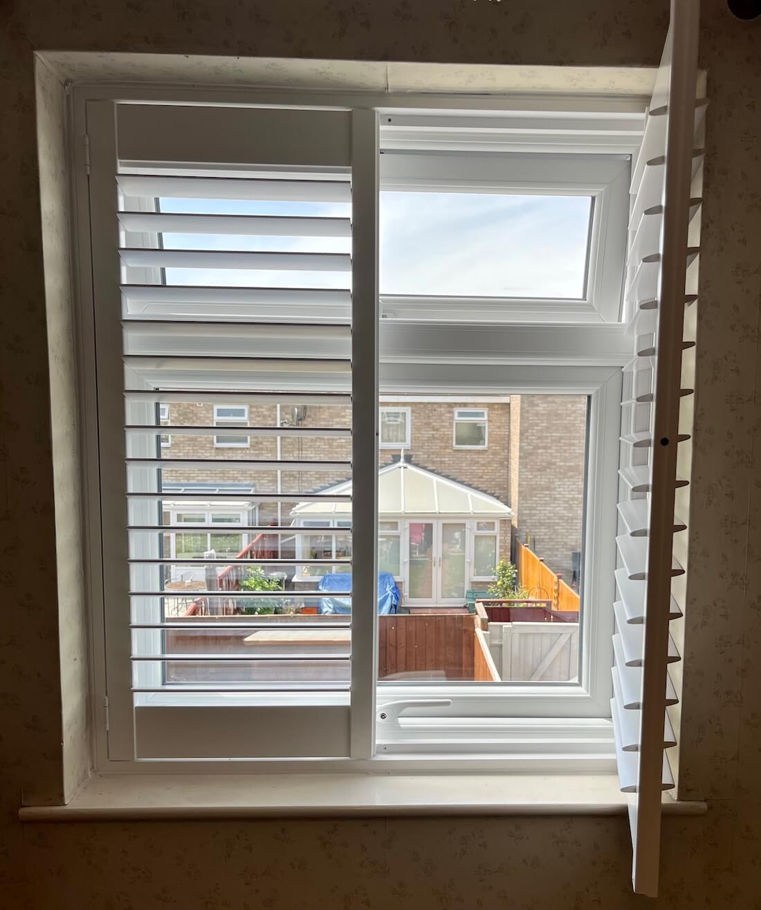 White shutters in a back bedroom overlooking the back garden.