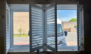 White shutters in a back bedroom overlooking the front driveway.