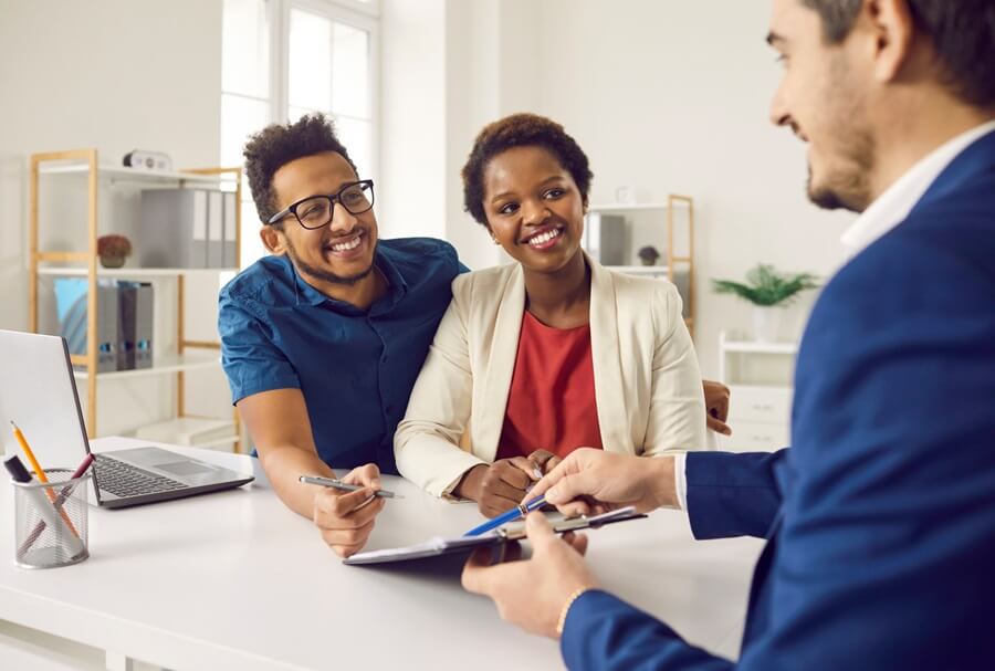 Just put your signature here. Married couple legalizes right of ownership of real estate in real estate agency. African American couple signs document provided by agent and becomes owner of apartment.