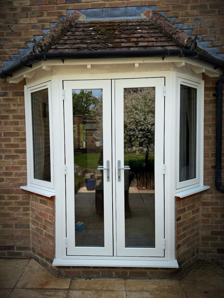 A set of uPVC french doors surrounded by brickwork