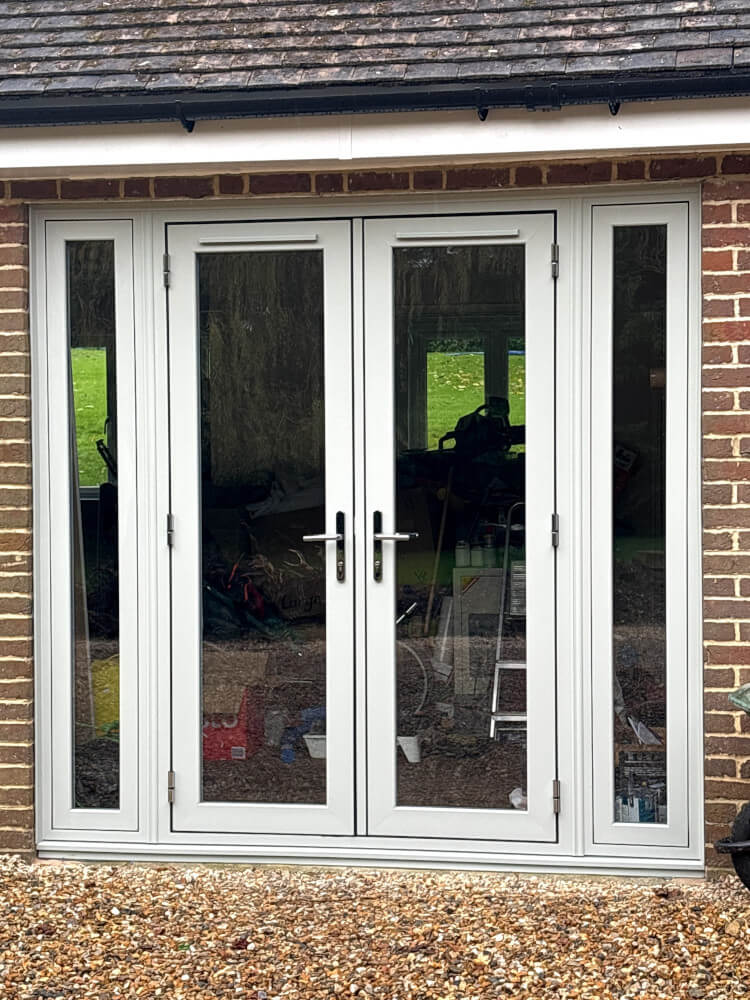 A set of French doors surrounded by brickwork.