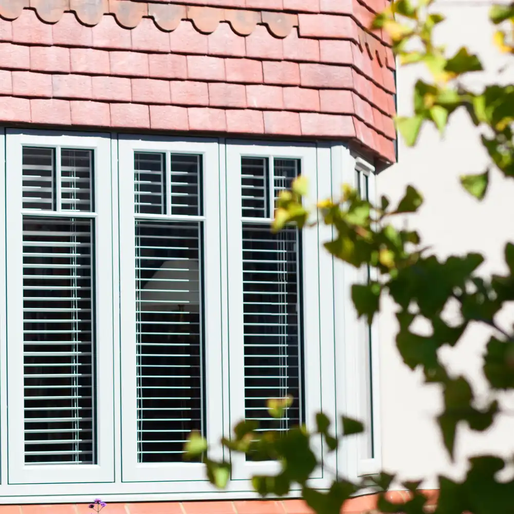 uPVC windows with red brickwork and a green tree outside